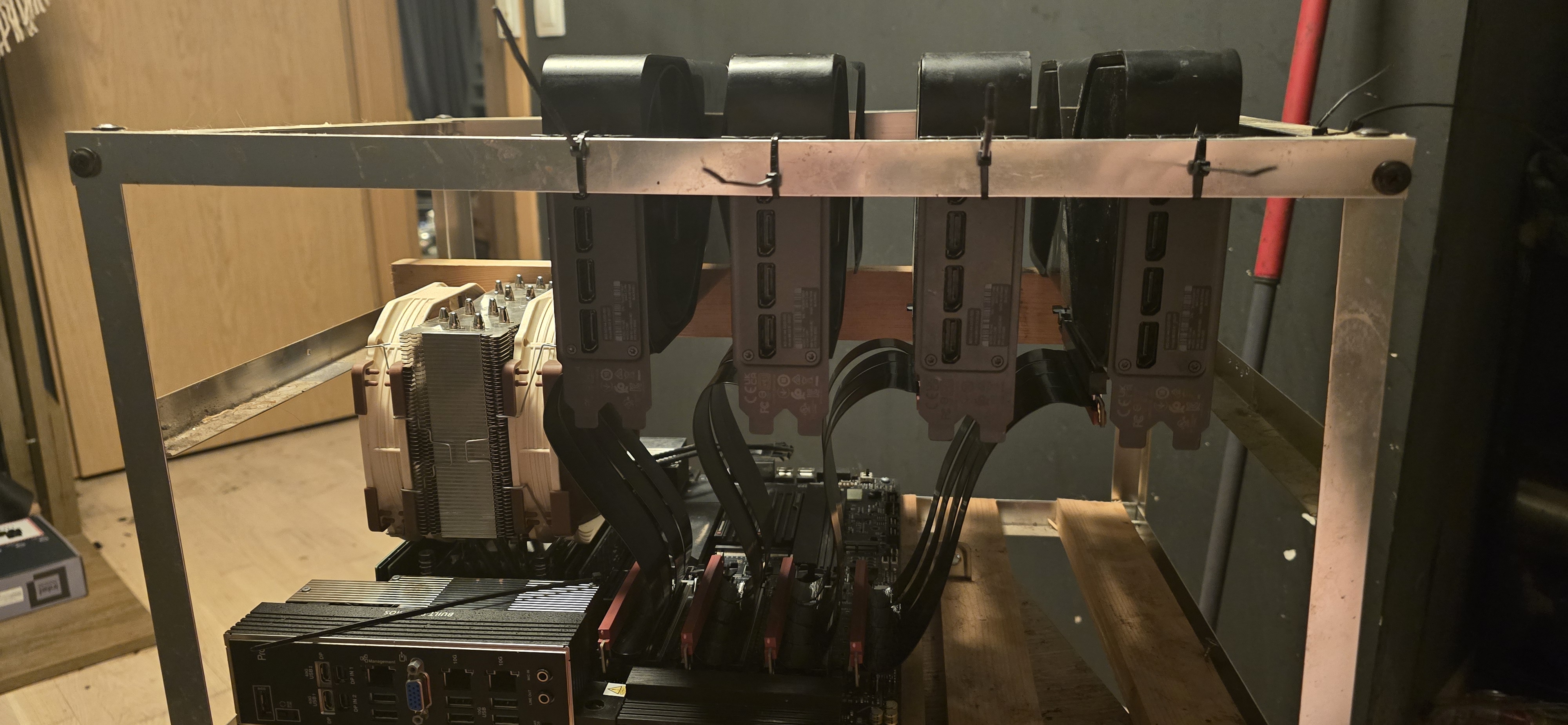 Front view of the rig: four cards with DisplayPort outputs, riser cables threaded down to the motherboard, Supermicro board with dual 10G ports below.